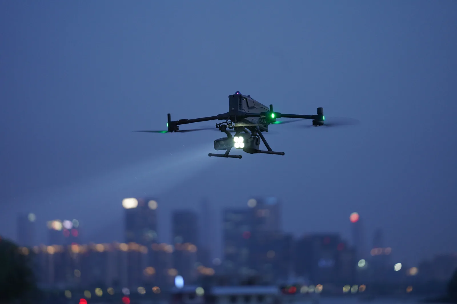 DJI Matrice 400 z zestawem trzech ładunków podczas nocnej operacji w terenie miejskim