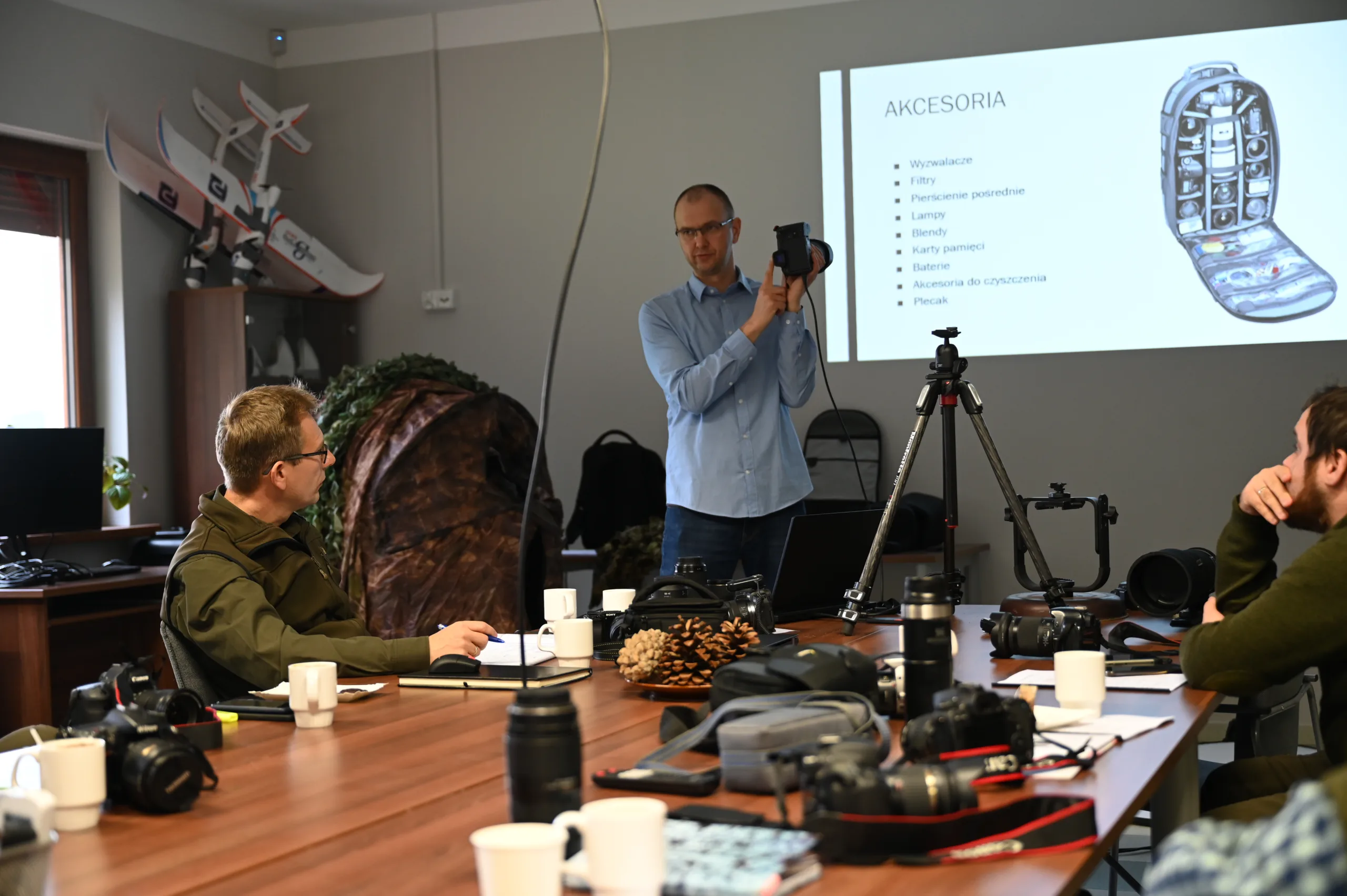 Instruktor prowadzi zajęcia teoretyczne przed grupą kursantów w sali szkoleniowej Era Dronów